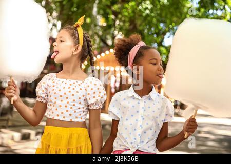 Carino bambine che mangiano caramelle di cotone all'aperto Foto Stock