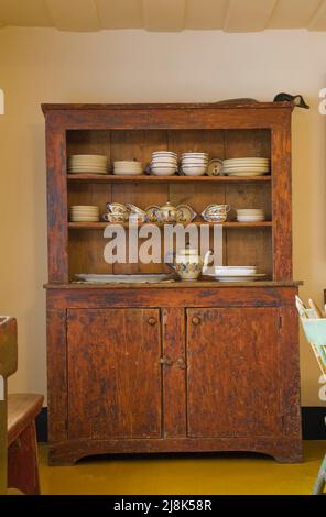 Buffet di stoviglie antiche con piatti raffinati in cucina all'interno della vecchia casa in stile cottage regime francese del 1780 circa. Foto Stock