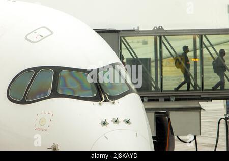 Un passeggero esce dall'aereo per entrare nel tunnel Foto Stock