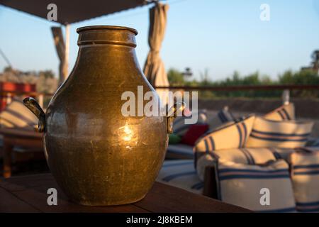 Un vaso di ottone vicino a mobili lounging su un Nile Dahabiya Tourist Boat Foto Stock