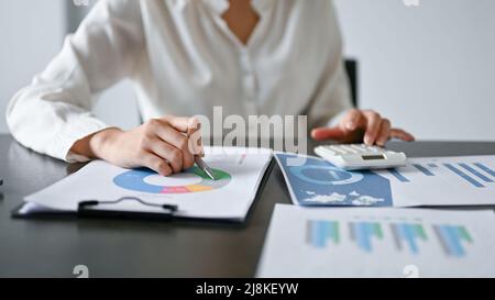 Immagine ritagliata, professionista o assistente finanziario che lavora in ufficio, analizzando i dati finanziari sul rapporto. Foto Stock