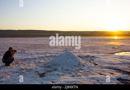 Il fotografo scatta foto del sale sul lago. Baku. Azerbaigian. Foto Stock