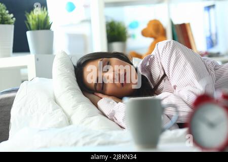 Giovane donna che dorme tranquillamente a letto, donna stanca, notte dura, insonne Foto Stock