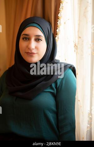 Giovane donna musulmana che indossa hijab al coperto Foto Stock