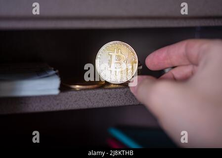 Piccola volta residenziale con bitcoin fisico. Bitcoin in una cassetta di sicurezza. Foto Stock