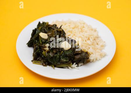 spinaci fritti con aglio e riso bollito sul piatto Foto Stock