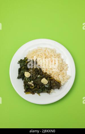 spinaci fritti con aglio e riso bollito sul piatto Foto Stock