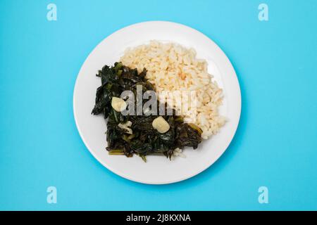 spinaci fritti con aglio e riso bollito sul piatto Foto Stock