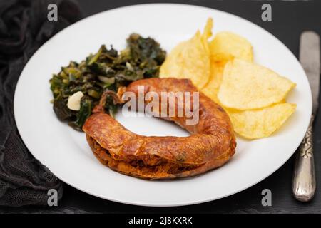 salsiccia tipicamente portoghese affumicata fritta con patatine e spinaci Foto Stock