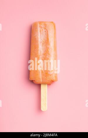 Ghiacciato fruttato. Dolce pop cicle su un tavolo rosa. Vista dall'alto. Foto Stock