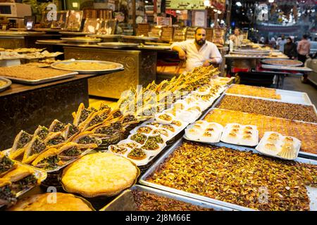 Damasco, Siria - Maggio 2022: Dessert e dolci arabi, baklava, pasticceria e panetteria in vendita su strada Foto Stock