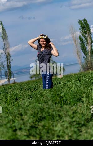 Vista ritagliata della donna in piedi nel campo del trifoglio, ripresa con fuoco selettivo. Foto Stock