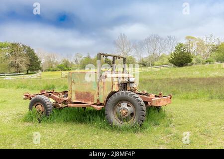 Un vecchio veicolo seduto in un campo verde Foto Stock