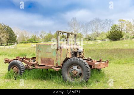 Un vecchio veicolo seduto in un campo verde Foto Stock