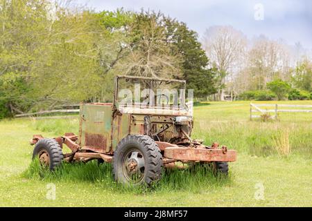 Un vecchio veicolo seduto in un campo verde Foto Stock