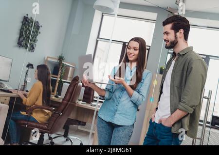 Foto di uomini d'affari di successo che lavorano su una nuova ragazza progetto mostrando il suo tirocinante i suoi doveri in netbook in ufficio moderno Foto Stock