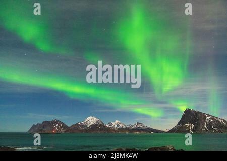 Luci verdi di Aurora Borealis su maestose montagne e mare, Myrland, Leknes, Vestvagoy, Isole Lofoten, Norvegia Foto Stock