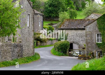 Tranquillo villaggio Conistone (edifici in pietra attraente, campi verdi su ripida collina valle, strada tortuosa) - Wharfedale, Yorkshire Dales, Inghilterra, Regno Unito. Foto Stock