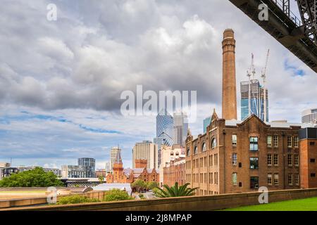 Sydney, Australia - 16 aprile 2022: Patrimonio storico 1916 Metcalfe Bond Stores edificio presso le rocce visto da sotto il ponte. Moderno edificio cittadino Foto Stock