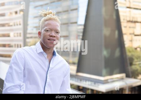 Ritratto di albino afro-americano medio uomo d'affari adulto in piedi in ufficio balcone Foto Stock