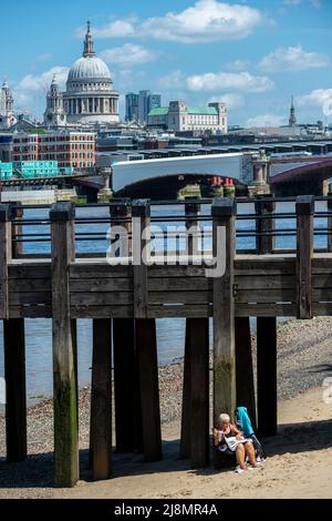 Londra, Regno Unito. 17 maggio 2022. Tempo del Regno Unito – una donna sulla spiaggia del Tamigi a bassa marea vicino al punto di osservazione sulla South Bank in un giorno in cui le temperature sono previste per salire a 26C. Credit: Stephen Chung / Alamy Live News Foto Stock