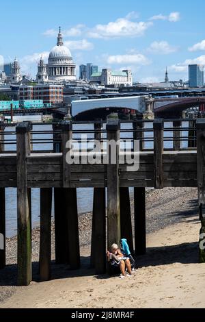 Londra, Regno Unito. 17 maggio 2022. Tempo del Regno Unito – una donna sulla spiaggia del Tamigi a bassa marea vicino al punto di osservazione sulla South Bank in un giorno in cui le temperature sono previste per salire a 26C. Credit: Stephen Chung / Alamy Live News Foto Stock