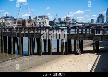 Londra, Regno Unito. 17 maggio 2022. Tempo del Regno Unito – una donna sulla spiaggia del Tamigi a bassa marea vicino al punto di osservazione sulla South Bank in un giorno in cui le temperature sono previste per salire a 26C. Credit: Stephen Chung / Alamy Live News Foto Stock