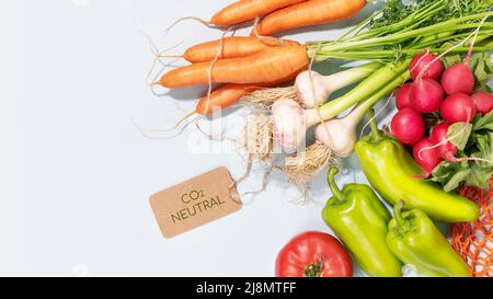 Verdure di stagione naturali con etichetta con scritta carbonio neutro su sfondo blu con spazio di copia. Ortaggi biologici freschi di fattoria. Vendere mari Foto Stock