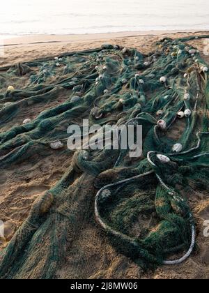 Rete da pesca scartata sulla spiaggia. Concetto di inquinamento marino. Foto Stock