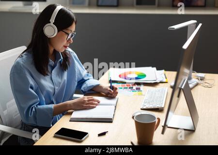Ritratto di femmina Asian Designer scrittura in notebook Foto Stock