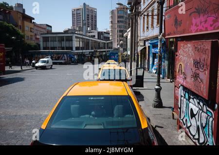 Valparaiso, Cile - Febbraio, 2020: Taxi con tetti gialli parcheggiati in fila lungo Avenida Ecuador strada nel quartiere Bellavista. Fila di taxi della città parcheggiata Foto Stock