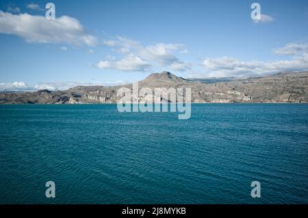 Vista delle montagne dalla riva del Lago generale Carrera Lago, Puerto Ibanez, Aysen, Cile. Giorno d'estate al lago glaciale con acqua limpida e blu Foto Stock