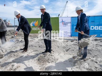 17 maggio 2022, Meclemburgo-Pomerania occidentale, Mukran: Frank Kracht (l-r), sindaco di Sassnitz, Jochen Schulte, segretario di Stato al ministero dell'economia, delle infrastrutture, del turismo e del lavoro, E Iris Stempfle, Managing Director di Iberdrola in Germania, svolgono la cerimonia simbolica rivoluzionaria per la costruzione di un centro operativo per le centrali eoliche offshore nel porto di Mukran. Martedì, la società energetica Iberdrola ha iniziato la costruzione di una seconda costruzione di impianti eolici offshore a Sassnitz, sull'isola di Rügen. Saranno operate altre due centrali eoliche offshore, mai Foto Stock