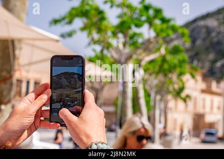 Immagine ritagliata dell'uomo che fotografa attraverso il cellulare in città Foto Stock