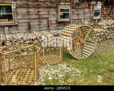 I cestini di legno usati per la raccolta delle ostriche sono immagazzinati dietro un capannone in una fattoria di ostriche vicino Willapa Bay in Washington. Foto Stock