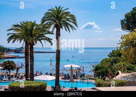 Vista panoramica dei turisti che si godono in spiaggia resort dal mare contro il cielo blu Foto Stock