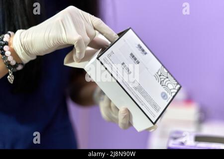 Mani con guanti sterili che rimuovono il farmaco da una scatola Foto Stock