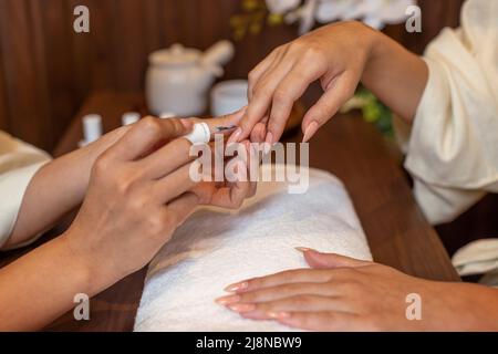 Unghie artista lucidare unghie per il cliente. Foto Stock