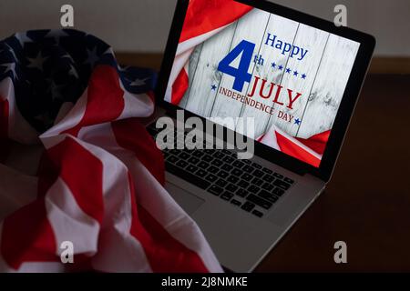 Computer portatile con Iscrizione Happy Independence Day sulla bandiera degli stati uniti. Foto Stock