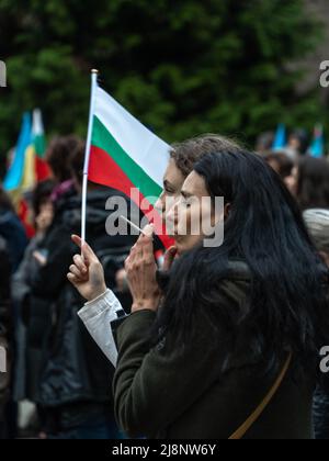Sofia, Bulgaria - 28 aprile 2022: Due donne di mezza età si levano in fila con una piccola bandiera bulgara durante una manifestazione Foto Stock