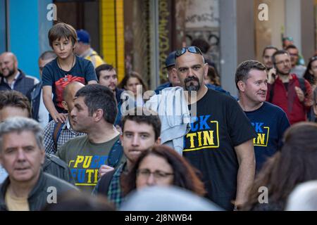 Sofia, Bulgaria - 09 maggio 2022: Tre uomini di mezza età dall'aspetto artistico, vestiti in magliette Puck Futin camminano nella folla per strada Foto Stock