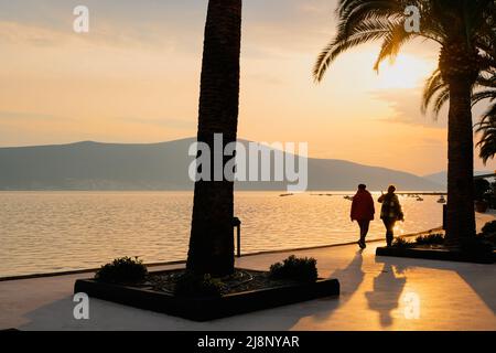 coppia di sagome che camminano sulla spiaggia al tramonto tropicale. paesaggio panoramico con orizzonte di luce e ombre Foto Stock