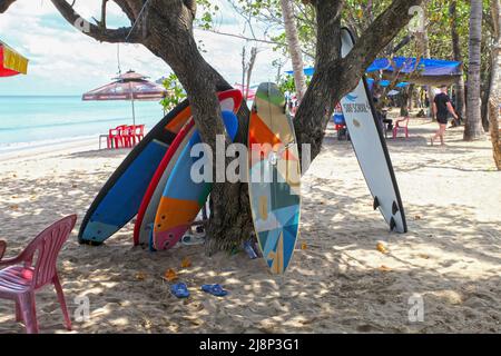 Kuta Beach scena a Bali, Indonesia nel marzo 2022 durante la pandemia con pochi turisti, venditori di bevande, ombrelloni e una spiaggia tranquilla. Foto Stock