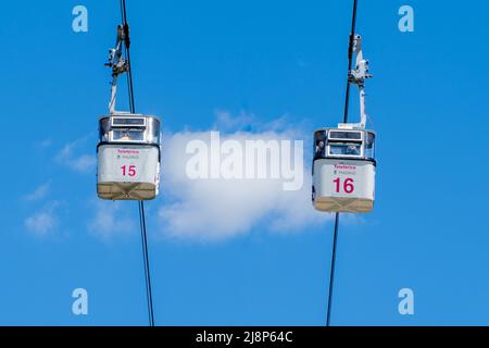 Madrid, Spagna; 04242022: Due cabine della funivia di Madrid si incrociano mentre i loro passanti scattano foto dall'interno con i loro cellulari. Telefe Foto Stock