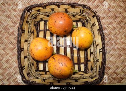 Passionfruits in cesto di vimini. Giallo Passionfruit. Deliziosi frutti della passione nel cestino Passionfruit Foto Stock