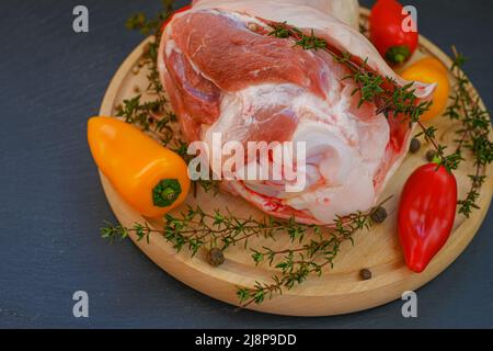 Carne di maiale sull'osso, pepe fresco dolce e timo erbe su una tavola rotonda su un fondo di ardesia.prodotti a base di carne. Foto Stock