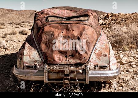 Vecchio arrugginito abbandonato l'auto d'epoca d'epoca nel deserto Foto Stock