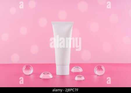 Mockup tubo di plastica bianco crema cosmetica senza marchio su sfondo rosa. Confezione di prodotti di bellezza per il corpo e la salute in bianco. Crema idratante per le mani Foto Stock