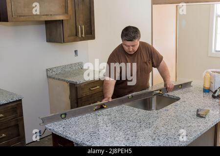 Lavoratore appeso livello sul piano di lavoro di armadi di cucina Foto Stock