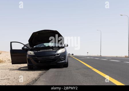auto nera con cofano aperto sul lato della strada Foto Stock